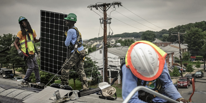 Dexter Rawlings, left, Dominic Paul-Baha, center, and Antwain Nelson, right, work on a solar panel installation on the roof of Catherine Bennett's home in Washington